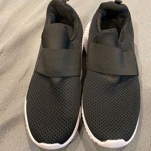 Black slip on laceless athletic shoes.  Shoes come pretty wide